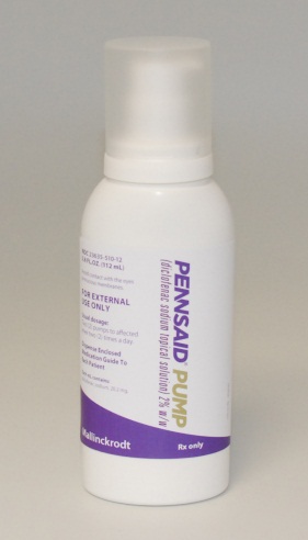 Of a white plastic bottle with a purple label. The label has the brand name "Pennsaid Pump" written in bold black letters at the top followed by "Rx only" in smaller black letters. Below that there is a description of the product which states that it is an external pump for external use only. The bottle has a white cap and is standing upright on a plain white background.