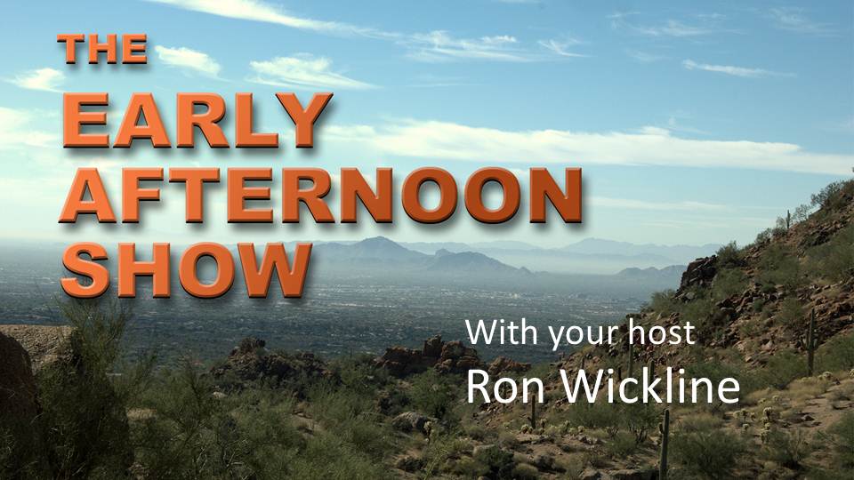 A landscape photograph of a mountain range with a clear blue sky in the background. The mountains are covered in greenery and there are a few trees and shrubs scattered throughout the landscape. In the center of the image there is a text overlay that reads "The Early Afternoon Show with your host Ron Wickline." The text is in orange and is in a bold font.