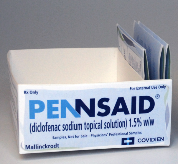 Of a white box with the word "Pennsaid" written in blue and black letters on the front. The box is labeled "Rx Only" and "For External Use Only". On the top right corner of the box there is a label that reads "diclofenac sodium topical solution 1.5% w/w". On top of the label there are two small packets of the same solution one with a blue label and the other with a white label. The packets are open and appear to be filled with the solution. The label also mentions that the solution is not for sale as indicated by the "Samples Not for Sale - Physicians' Professional Samples" label.