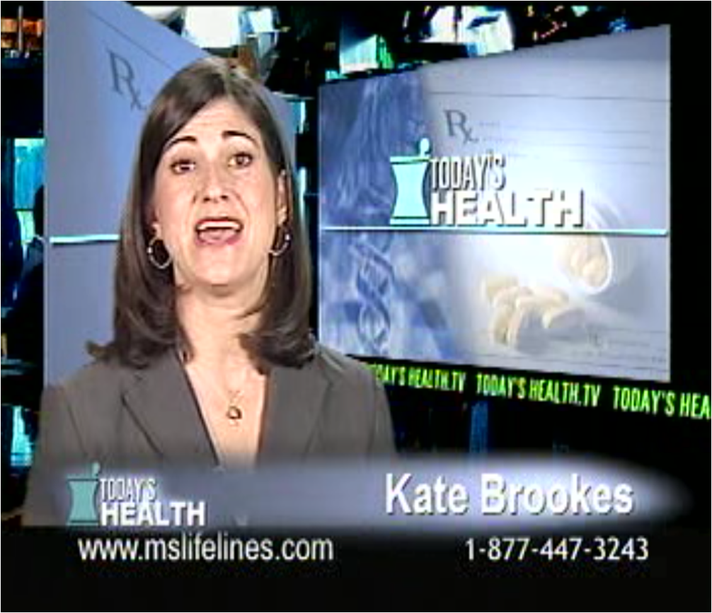 A screenshot from a news segment on Today's Health. It shows a woman Kate Brooks in the center of the screen. She is wearing a black blazer and has shoulder-length dark hair. She appears to be speaking and is looking directly at the camera with a serious expression on her face. The background is blurred but it seems like she is in a news studio or a news station. On the right side of the image there is a large screen with the words "Today's Health" and a logo of a pill bottle. Below the screen there are numbers and text that read "www.mslifelines.com" and "1-877-447-3243".