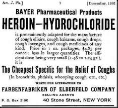 A black and white advertisement for Bayer Pharmaceutical Products' Heroin-Hydrochloride. The advertisement is dated December 1901 and is titled "The Cheapest Specific for the Relief of Coughs". The advertisement states that the product is pre-eminently adapted for the manufacture of cough elixirs cough balsams cough drops cough lozenges and cough medicine of any kind. Price in 1 oz. packages $4.85 per ounce less in larger quantities. It is in bronchitis phthisis whooping cough etc. etc. The company's name Farbenfabrikken of Elberfeld Company is written at the bottom of the advertisement.