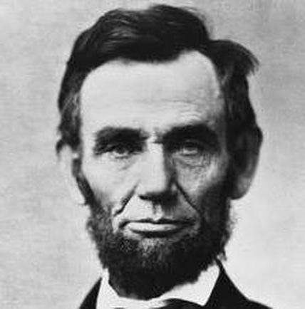 A black and white portrait of a man's face. The man appears to be in his late twenties or early thirties with dark hair and a beard. He has a serious expression on his face with his eyes closed and his mouth slightly open. He is wearing a suit and tie and his hair is styled in a slicked-back manner. The background is plain and blurred making the man the focal point of the image.