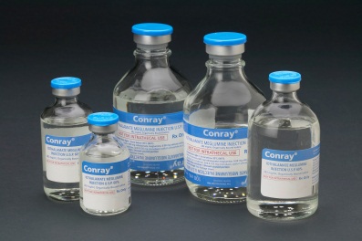 A group of five small glass vials with blue caps. The vials are arranged in a row and are of different sizes and shapes. Each vial has a white label with the brand name "Conray" written on it. The labels also mention that the vials contain a clear liquid which appears to be a type of medication. The bottles are of varying sizes with the largest one in the center and the smallest one on the left. The background is black making the blue caps stand out.