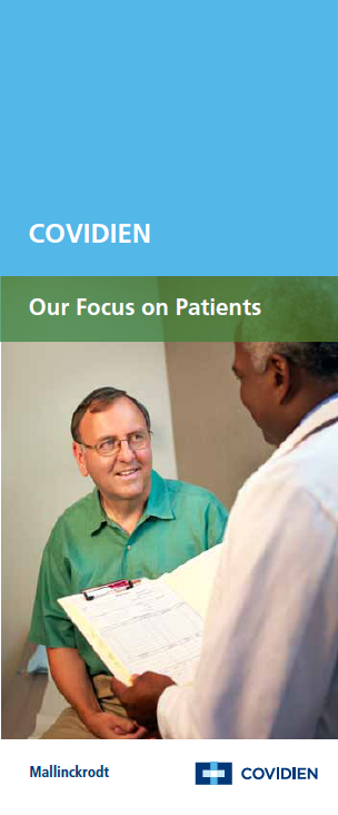 A man in a green shirt sitting on a couch and smiling at a doctor who is standing in front of him. The doctor is holding a clipboard and appears to be explaining something to the man. The background is a plain white wall. The image is accompanied by text that reads "COVIDIEN - Our Focus on Patients".