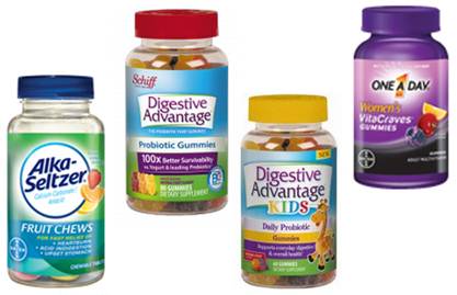 Four different types of gummies. On the left there is a bottle of Alka-Seltzer fruit chews. The bottle is green with a blue label and has a red cap. Next to it there are two bottles of Digestive Advantage Probiotic Gummies. The one on the right is a purple bottle with the words "One a Day" and "Women's Vitamins" written on it. The other two bottles are yellow and have the same label. All four gummies appear to be new and unused.