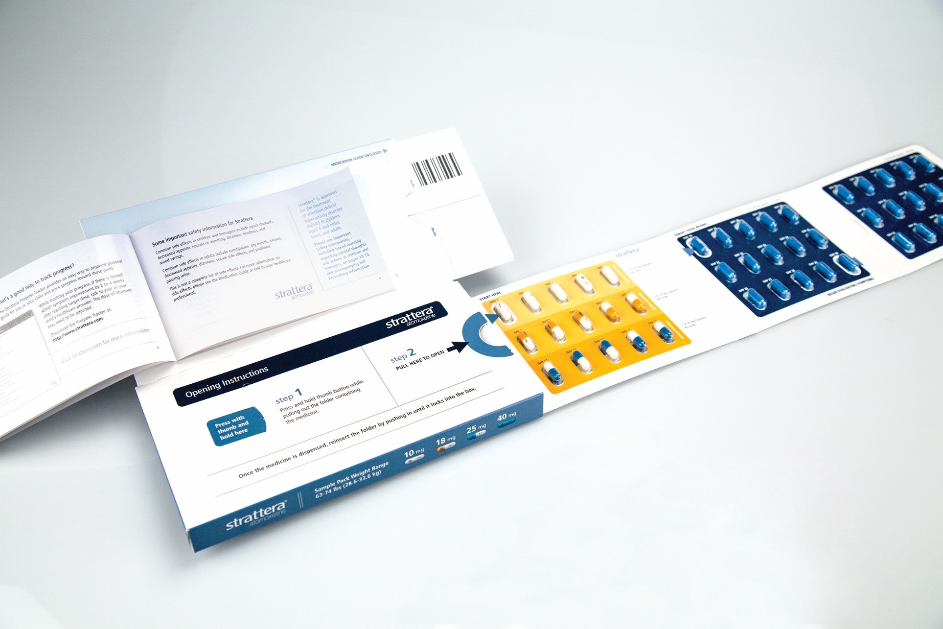 An open brochure or pamphlet with a blue and white design. The brochure is lying on a white surface and is open to a page with text and a barcode. On the right side of the brochure there is an illustration of a blister pack of blue pills. The blister pack is divided into three sections each with a different color and design. <br /><br />The first section has a blue background with white text while the second section has an orange background with blue text. The text on the left side has a white background with black text. There is also a blue barcode on the top right corner of the page.<br /><br />At the bottom of the left corner there are two pages of text one with a title and the other with a description of the product. The first page has a list of ingredients and instructions and the second page has an image of the pills.