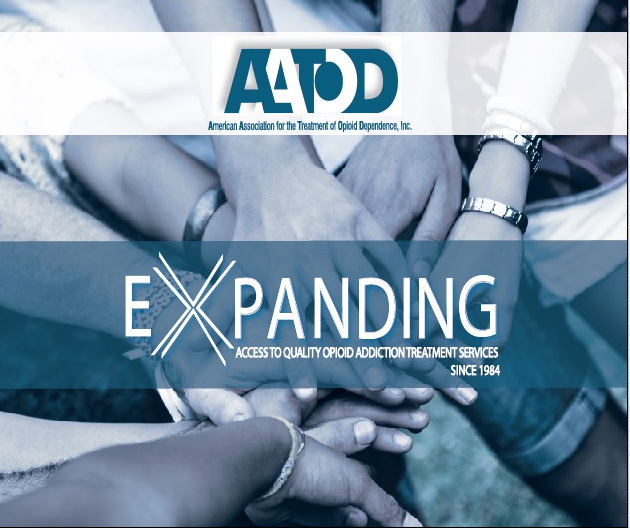 A logo for the American Association for the Treatment of Opioid Dependency Inc. The logo is a blue and white circle with the letters "AADD" in the center. Below the logo there is a text that reads "Expanding" in white letters. The text below the logo reads "Access to quality opioid addiction treatment services since 1984". <br /><br />In the center of the image there are several hands of different ages genders and ethnicities stacked on top of each other forming a circle. The hands are intertwined symbolizing unity and togetherness. The background is blurred but it appears to be an outdoor setting with trees and greenery.