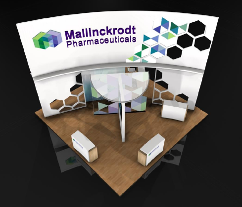 A 3D rendering of a trade show booth for Mallinckrodt Pharmaceuticals. The booth has a white background with a colorful geometric design on the top left corner. On the right side of the booth there is a large banner with the company's logo and name in bold black letters. Below the banner there are two white boxes on a wooden table. The table is in the center of the image and has a glass top. The overall design is modern and minimalistic.