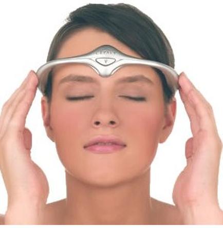 A young woman with her eyes closed holding a silver headband over her head. The headband appears to be made of metal and has a curved shape with a small diamond-shaped design on it. The woman has short dark hair and is wearing minimal makeup. She is holding the headband with both hands and appears to have a peaceful expression on her face. The background is plain white.
