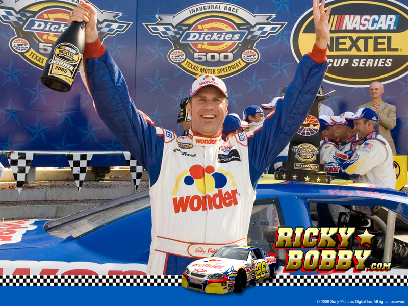 A man Ricky Bobby from the movie Talladega Nights in front of a race car with his arms raised in triumph. He is wearing a blue and white racing suit with the Wonder Bread logo written across the chest. He has a big smile on his face and is holding up a bottle of champagne in his right hand. In the background there are banners that read "Dickies 500" and "NASCAR Nextel Cup Series". There is a logo for RickyBobby.com with an icon of his race car at the bottom of the page. 