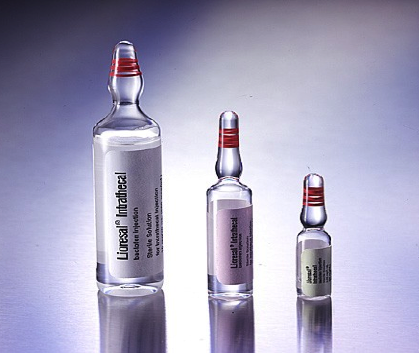 Three vials of Lioresal Intrathecal baclofen injection sterile solution of different sizes. The vials are made of a clear substance with red lines on their cap and have white labels with black text. The background is various shades of grey and white with the vials appearing to be resting on a reflective surface (which is not itself visible).