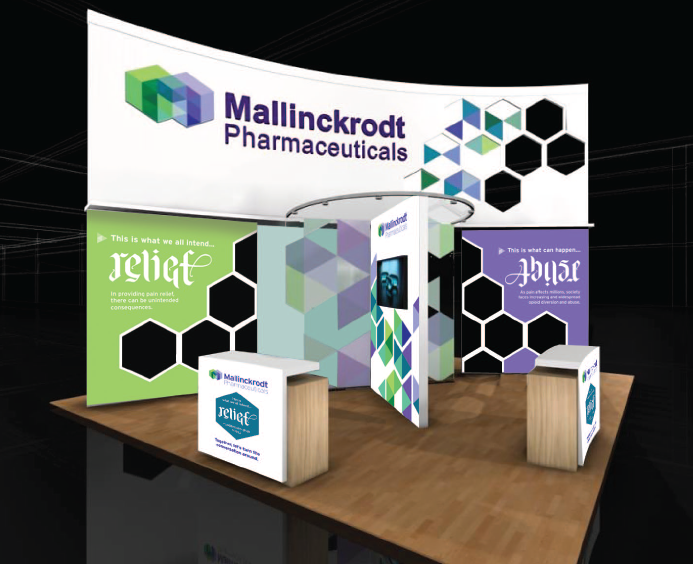 A trade show booth with a large banner that reads "Mallinckrodt Pharmaceuticals" in bold colorful letters. The banner is decorated with a geometric pattern of green blue and purple hexagons. Below the banner there is a green banner with the word "Relief" written in white letters. On the right side of the booth there are two smaller banners with the same text. The booth is set up on a wooden table with a black background.