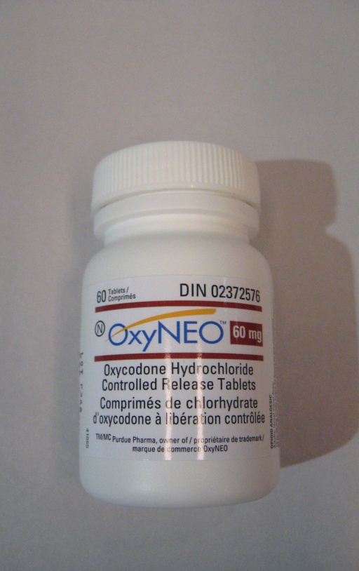 A photograph of a white plastic bottle with a white cap. The bottle is labeled with the brand name "OxyNEO" and the product name "DIN 02372576" in black text. The label also mentions that the bottle contains 60 mg of Oxycodone Hydrochloride Controlled Release Tablets. The product is a combination of hydrochloride and hydrochloric acid which are used to control the release of the release. The background is plain white making the bottle the focal point of the image.