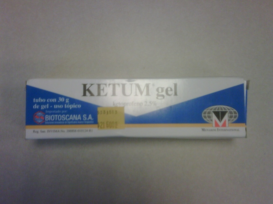 A photograph of a tube of Ketum gel. The tube is white with blue and yellow accents. The label on the tube reads "KETUM gel" in bold black letters. Below the label there is a description of the product which states that it is a tubo con 30 g de gel - uso tÃ3pico biotoscana S.A. and that it contains 2.5% of the gel. On the right side of the tube there are two logos - one is a red and white shield with the letter "M" in the center and the other is a blue and white checkered pattern. The background of the label is plain white.