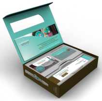 A brown cardboard box with a turquoise lid. The lid is open revealing the contents inside. On the top of the box there is a white label with a blue and green design. The label has an image of a woman's face and the text "Beauty Salon". Below the label there are two business cards with different designs on them. The cards appear to be for a beauty salon or spa. The box is rectangular in shape and has a handle on the top for easy carrying.