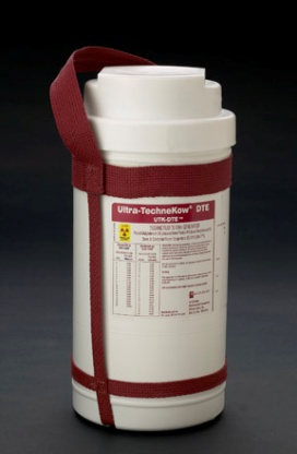 A white cylindrical container with a red strap attached to it. The container appears to be made of plastic and has a label on it that reads "Ultra-Technikow DTE". The label also has some information about the product such as its size capacity and other specifications. The strap is secured around the container with two red straps. The background is black making the container stand out.