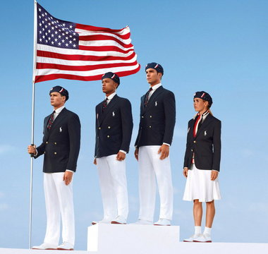 Four young men in formal attire standing on a white pedestal with an American flag in front of them. They are all wearing navy blue blazers white trousers and black caps. The man on the left is holding the flag with his right hand while the man in the middle is holding it with his left hand. The woman on the right is standing with her hands on her hips looking up at the flag. The background is a clear blue sky. The image appears to be a 3D rendering giving it a realistic look.