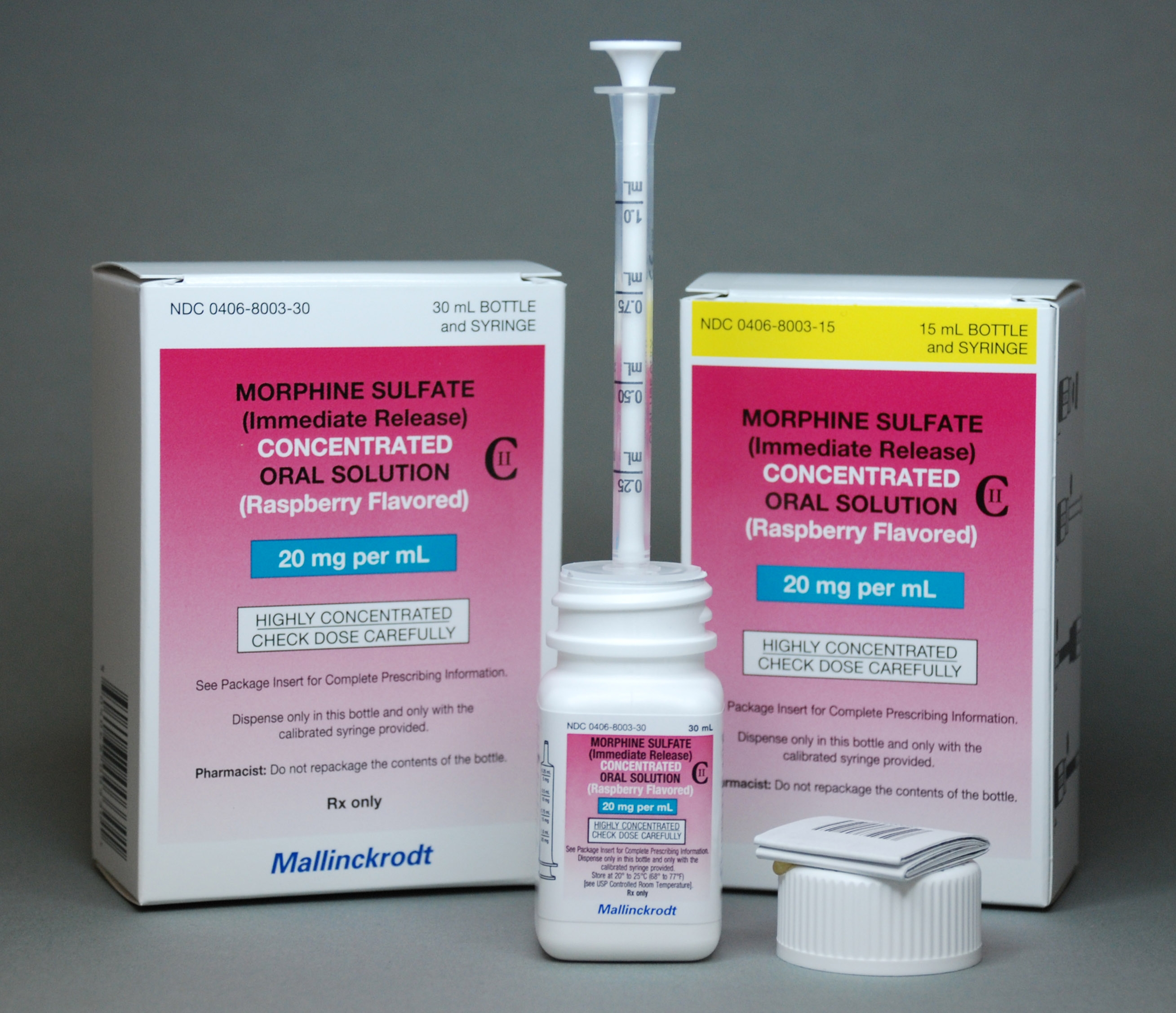 A white box with a pink label that reads "Morphine Sulfate (Immediate Release) Concentrated Oral Solution (Raspberry Flavored) 20 mg per ml". Next to the box there is a white syringe with a white cap. The syringe is filled with a clear liquid and the cap is open. The box also has a label on it that says "Highly Concentrated" and "20 mg per mL". The background is a plain grey color.