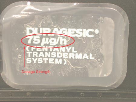 A clear plastic container with a label on it. The label reads "DURAGESIC" in bold black letters. Below the label there is a red circle with the text "75g/h" in white letters. The text below the red circle reads "PENTANYL TRANSDERMAL SYSTEM" in smaller black letters indicating that the container contains a substance called "Dosage Strength". The container appears to be sealed and is placed on a black surface.