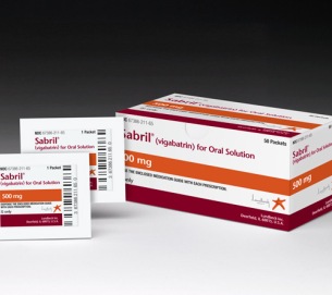 A white box with orange and red stripes and the brand name "Sabril" written on it. The box is labeled "Vigabatrin for Oral Solution" and has a barcode on the left side. On the right side of the box there is a small white card with the same brand name and product details. The card is placed next to the box. The background is plain white.