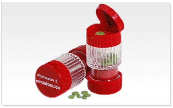 A red pill bottle with a red cap. The bottle is cylindrical in shape and has a label on the front that reads "Pillmaster 2". The cap is open revealing the contents inside. On the right side of the bottle there is a small amount of green pills spilling out of it. The pills appear to be small and round and they are scattered around the bottle. The background is white.