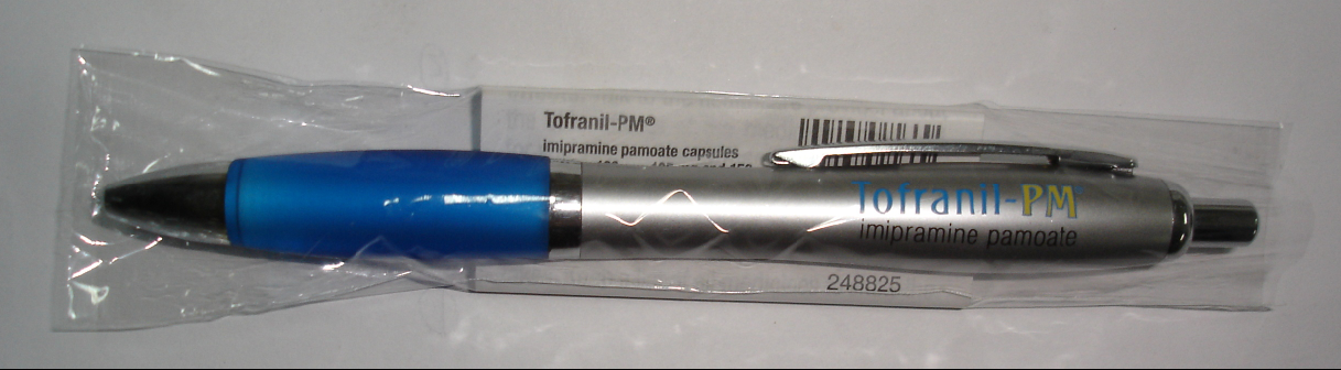 A blue and silver pen with the brand name "Tofranil PM" written on it. The pen is wrapped in a transparent plastic bag with a barcode and the number "248825" printed on the bottom right corner. The packaging of the pen is also visible in the background.