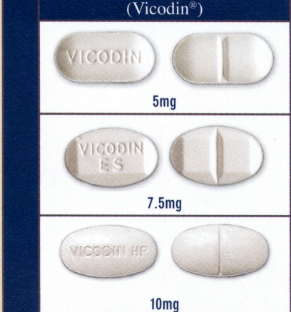 Four oval-shaped pills with the word "Vicodin" written on them in white text. The pills are arranged in a horizontal row with each pill having a different size and shape. The first pill is 5mg the second pill is 7.5mg and the third pill is 10mg. All the pills are white in color and appear to be made of a smooth glossy material. The background of the image is a light blue color.