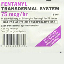 A label for a Fentanyl Transdermal System. The label is white with black text and a barcode on the left side. The text on the label reads "Fentanyl 75 mcg/hr" and "In vivo delivery of 75 mg/hr fentanyl for 72 hours. Not for acute or postoperative use. Each transdermal system contains: 7.65 mg fentanyl. One (75 mcg /hr) System." The label also has a purple triangle on the right side with the text "ATTENTION: Only use by patient for whom prescribed."