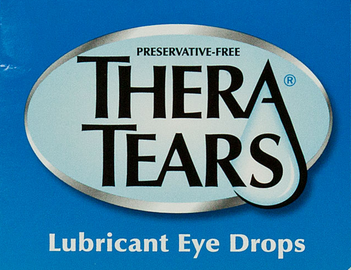 A blue box of Thera Tears lubricant eye drops. The box is rectangular in shape and has a white background. The brand name "Thera Tears" is written in bold black letters in the center of the box with the word "Preservative-Free" written in smaller black letters below it. The word "Lubricant Eye Drops" is also written in white letters above the brand name. The label also has a small logo of a dropper on the right side.