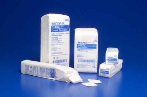 A group of medical supplies specifically Kendall Curity gauze sponges. There are three items in the image - a white packet with the brand name "Kendall" written on it a white bandage and a small white box with the product name "Curity" written in blue. The packet is rectangular in shape and appears to be made of a soft absorbent material. Next to the packet there is a smaller white box that is also made of the same material. The bandage is folded and placed on a blue background. There is also a small amount of white tissue paper scattered around the items. The overall appearance of the items is clean and sterile.