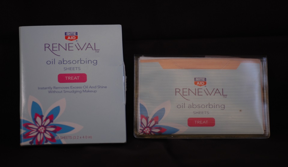 A box of Renewal Oil Absorbing Sheets. The box is rectangular in shape and has a white background with a blue and pink floral design on the front. The front of the box has the brand name "Renewal" written in bold black letters. Below that there is a description of the product which states that it is an instant removes excess oil and shine without smudging makeup. <br /><br />Next to the box there are two smaller boxes of the same product. The first box is white with a pink and blue floral design while the second box is orange with the same design. Both boxes have a label that reads "Treat" in red letters. The boxes appear to be new and unused.