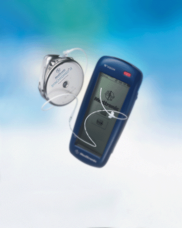 A blue electronic device which appears to be a hearing aid flying in the air. The device has a small screen and a red button on the top right corner. On the left side of the device there is a silver-colored hearing aid with a cord attached to it. The background is a light blue sky with white clouds. The image is taken from a low angle looking up at the device.