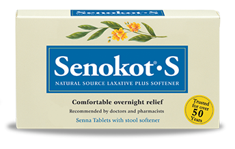 Of a box of Senokot's Natural Source Laxative Plus Softener. The box is rectangular in shape and has a light beige color. The front of the box has a blue and white label with the brand name and product name in bold black font. The label also has an illustration of a branch with orange flowers and green leaves. Below the label there is a description of the product which reads "Comfortable overnight relief recommended by doctors and pharmacists" and "Senna Tablets with stool softener". On the right side of the label is a yellow circle with the text "Trusted for over 50 years".