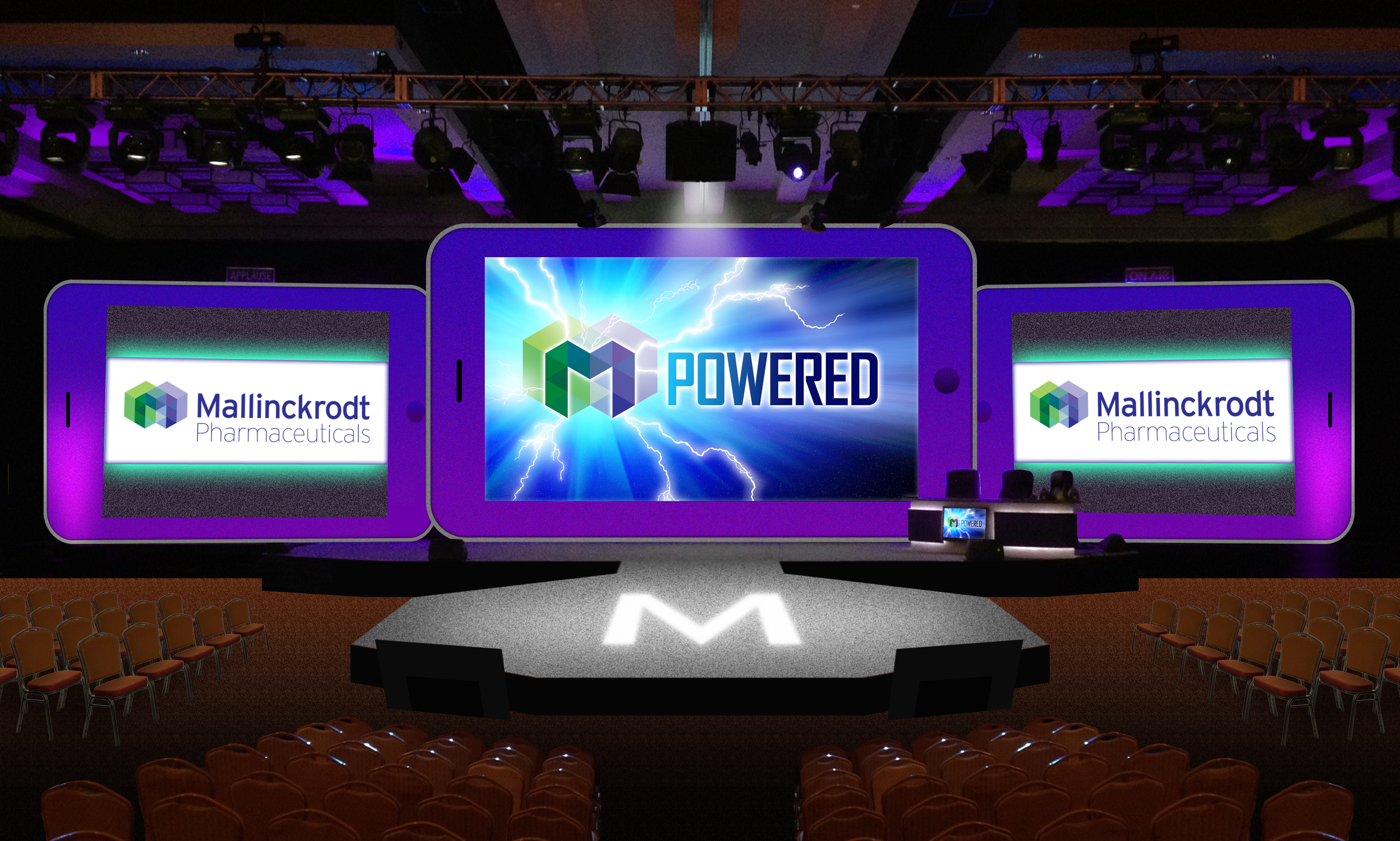 A stage set up for a presentation. The stage is rectangular in shape and has a black background. On either side of the stage there are rows of orange chairs facing the audience. In the center of the image there is a large screen with the word "POWERED" written in bold white letters. The screen also has a colorful logo of a lightning bolt and the text "Mallinckrodt Pharmaceuticals". On the left and right sides of the screen the same logo are displayed in purple and green colors. The overall design of the presentation is modern and professional.