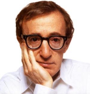 A portrait of a middle-aged man with short dark hair and glasses. He is wearing a white collared shirt and has a serious expression on his face. His hand is resting on his chin as if he is deep in thought or contemplating something. The background is plain white making the man the focal point of the image. He appears to be in his late 60s or early 70s.