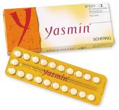 A pack of Yasmin tablets. The pack is rectangular in shape and has a yellow and orange color scheme. The top of the pack has the brand name "Yasmin" written in bold white letters with the word "Scheering" written below it in smaller white letters. The bottom of the packaging has the product name "SCHERING" written on it in black letters. There is also a red "Y" on the top left corner which is likely the brand's logo. The packaging also has a label on the right side that reads "671521 CX". The pack contains 12 white pills.