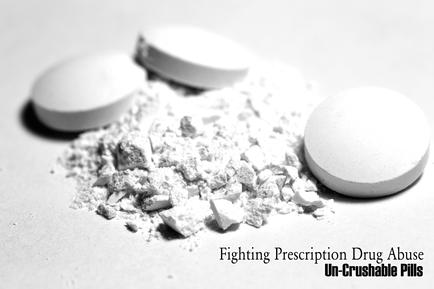 A black and white photograph of three white pills scattered on a white surface. The pills are round and appear to be un-uncrushable. One of the pills is lying on its side while the other two are lying on top of it. The background is plain and the focus is on the pills and the powdery substance. The text on the image reads "Fighting Prescription Drug Abuse: Un-uncrushable Pills".