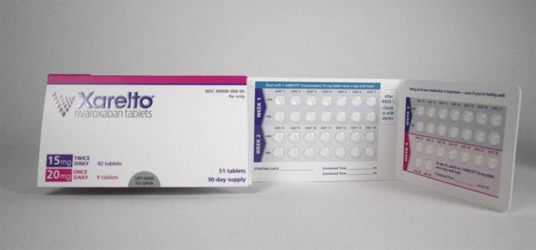 A pack of Xarelto tablets. The pack is white with pink and blue accents. The front of the pack has the brand name "Xarelto" written in bold blue letters. Below that there is a description of the tablets which states that they are 15mg each and are 20mg each. <br /><br />The back of the packaging has a list of the product's ingredients and nutritional information. The packaging also mentions that the tablets are 30-day supply. There is also a small image of the blister pack on the right side of the image.