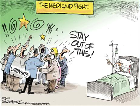 A cartoon illustration of a group of people gathered around a hospital bed. The people are holding signs that read "The Medicaid Fight" and "Stay Out of This!" The people in the image appear to be angry and frustrated with some of them shouting and others gesturing with their hands. There is a yellow star above the bed and a sign that reads "Lobbyists" below the bed. On the right side of the image there is a man lying in the hospital bed with his head resting on a pillow. The background is a plain white wall.