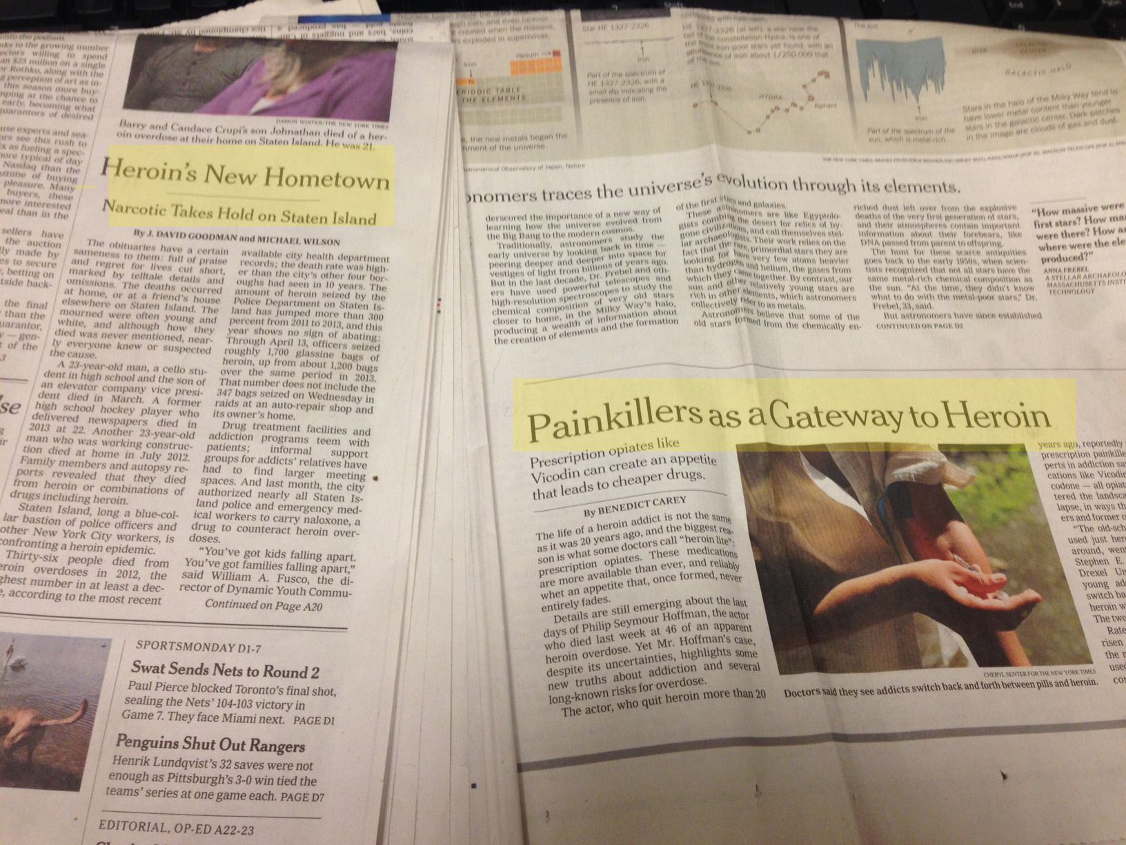 Two pages of a newspaper. The first page is titled "Heroin's New Hometown" and has a headline that reads "Painkillers as a Gateway to Heroin". The second page has an image of a person's hand holding a piece of paper with the headline "Painkiller's as Gateway to Heroin" written on it. The background of the page is white and there is a black keyboard visible in the top right corner. The newspaper appears to be old and worn with some creases and wrinkles on the pages.