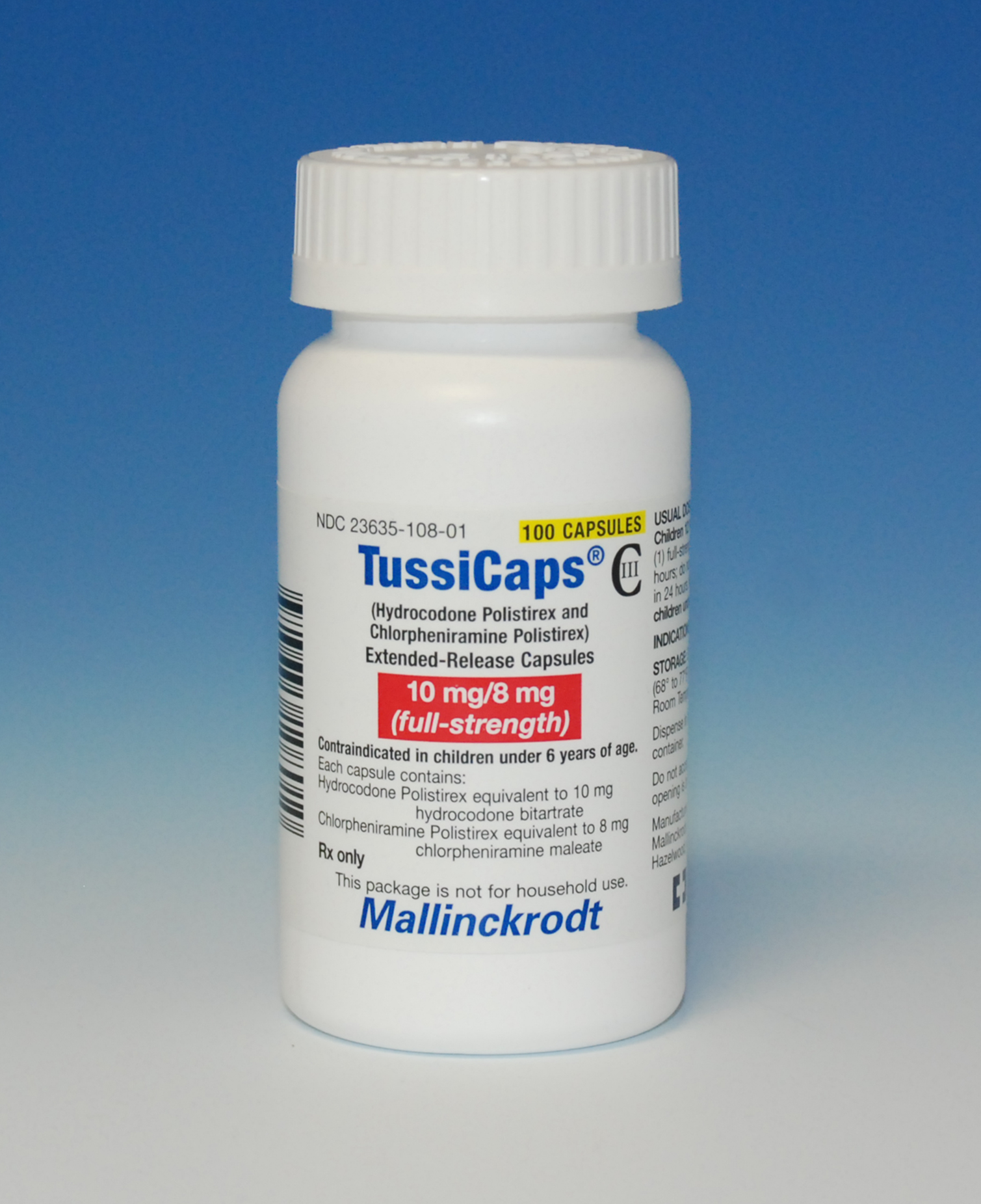 A photograph of a white plastic bottle with a white cap. The bottle is labeled "TussiCaps" and has a label that reads "100 Capsules" in bold black letters. Below the label there is a description of the product which states that it is "10 mg/8 mg (full-strength)". The label also mentions that the product is made in the United States and is manufactured by Mallinckrodt. The background of the image is light blue and the bottle is standing upright on a white surface.