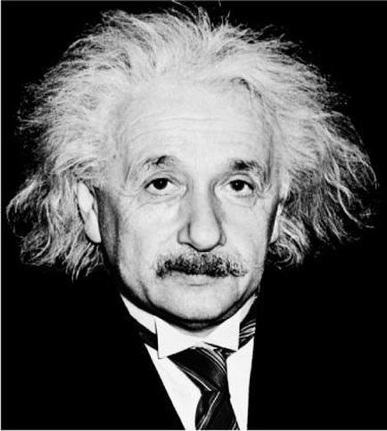 A black and white portrait of Albert Einstein. He is shown from the side looking directly at the camera with a serious expression on his face. His hair is styled in a messy curly manner and he has a mustache. He appears to be wearing a suit and tie. The background is completely black making Einstein the focal point of the image.
