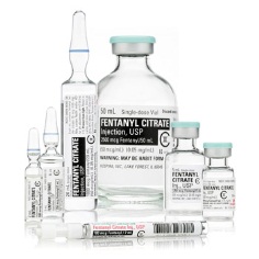 A collection of medical supplies including a vial of fentanyl citrate a syringe and two small vials. The vial is a clear glass bottle with a blue cap and a label that reads "Fentanyl Citrate Injection USP". The syringe is a small cylindrical vial with a dropper at the end. The other two vials are smaller rectangular vials with white caps. All the items are arranged in a neat and organized manner. The background is white making the items stand out.