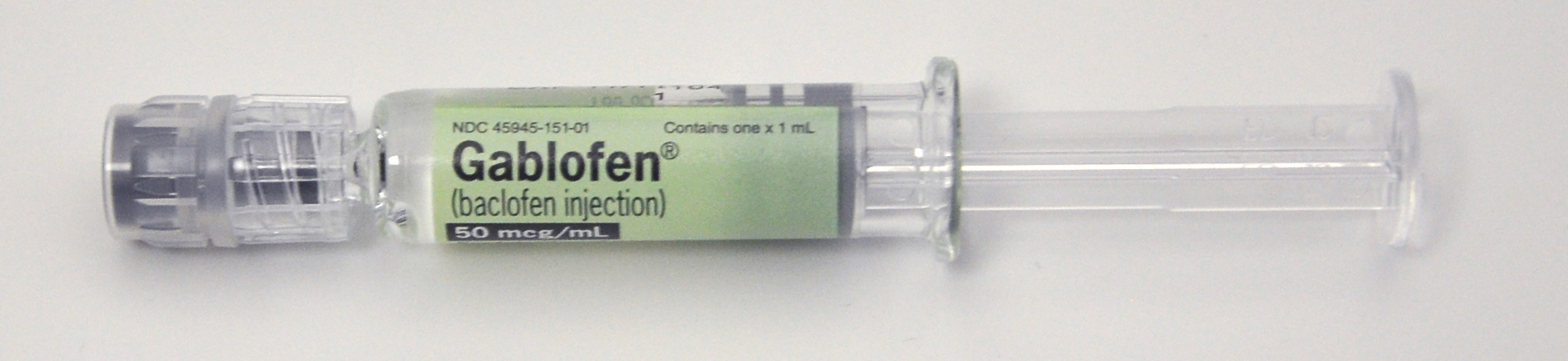 A syringe with a green label that reads "Gablofen (baclofen injection) 50 mg/ml". The syringe is made of clear plastic and has a cylindrical shape with a needle at the end. The label also has the brand name and dosage information printed on it. The syringes appear to be new and unused. The background is plain white.