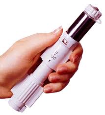 A hand holding a white-colored device with a black-colored cap. The device appears to be a flashlight as it has a cylindrical shape with a pointed end and a small opening at the top. The body of the device is made of plastic and has a textured surface for better grip. The cap is attached to the top of the cap with a small loop which is likely used to secure the device in place. The hand is holding the device with both hands and the background is plain white.