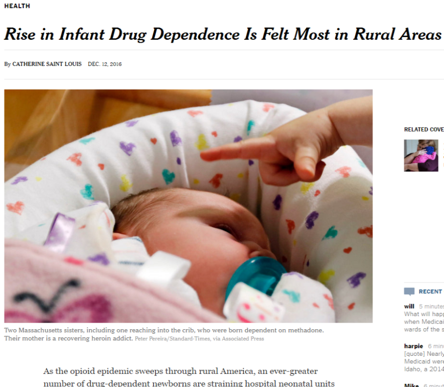 A newborn baby sleeping peacefully in a white bassinet with colorful hearts on it. The baby is wearing a blue pacifier and is resting its head on a pink blanket. A person's hand is pointing towards the baby. The image is accompanied by text that reads "Rise in Infant Drug Dependence Is Felt Most in Rural Areas" and "By Catherine Saint Louis Dec. 12 2016".