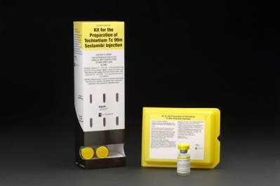 A kit for the Preparation of Technetium Tc 99m Sestamibi injection. The kit includes a white cardboard box with a black and yellow label on the front. The label has the product name and description written in bold black font. Next to the box there is a small yellow vial with a yellow cap. The vial is filled with a clear liquid. On the right side of the image there are two small yellow boxes with the same label. The boxes are placed on a black background.