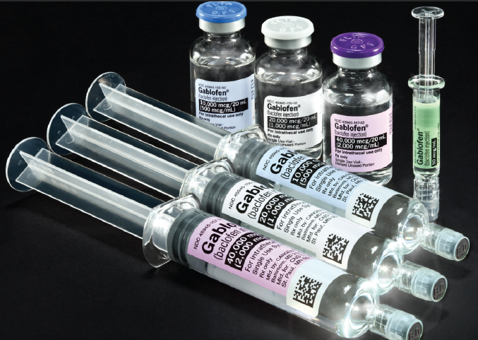 A group of six syringes of different sizes and shapes arranged in a row on a black background. There are six vials of different colors - one with a blue cap another with a purple cap the third with a white cap and the fourth with a green cap. All the vials have labels on them with the word "Gabor" written on them. The vials appear to be filled with a clear liquid possibly a vaccine or a similar substance. There is also a syringe with a needle on the right side of the image.