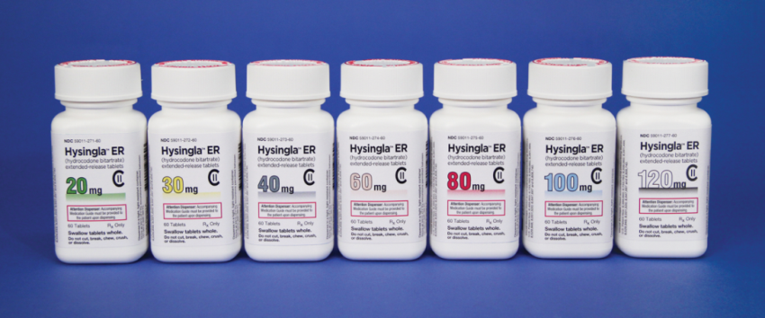 A group of nine white plastic bottles with red caps arranged in a row on a blue background. Each bottle has a label on it that reads "Hysingla ER" in bold black letters. The labels also mention that the bottles contain 20mg 30mg 40mg 60mg 80mg 100mg and 120mg of the medication. The bottles appear to be new and unused.