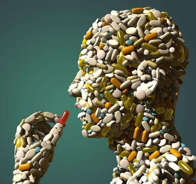 A 3D rendering of a human head made up of various pills and capsules. The pills are of different colors and sizes including white orange yellow and green. The capsules are arranged in a way that they form the shape of the head. The background is a solid turquoise color making the colors of the pills stand out. The overall mood of the image is one of concentration and focus.